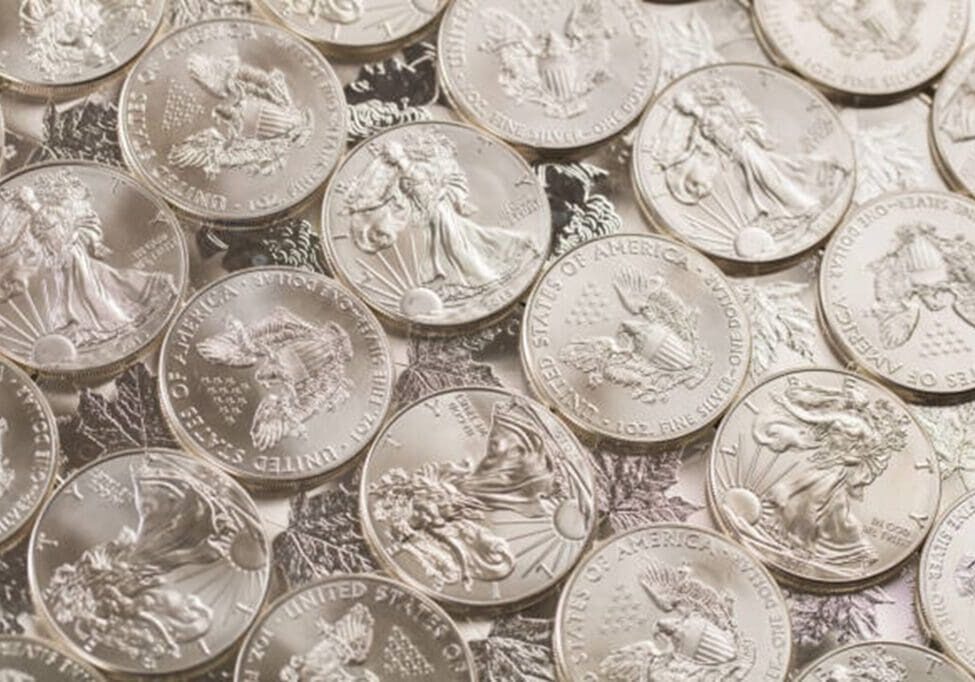 A pile of silver coins sitting on top of each other.